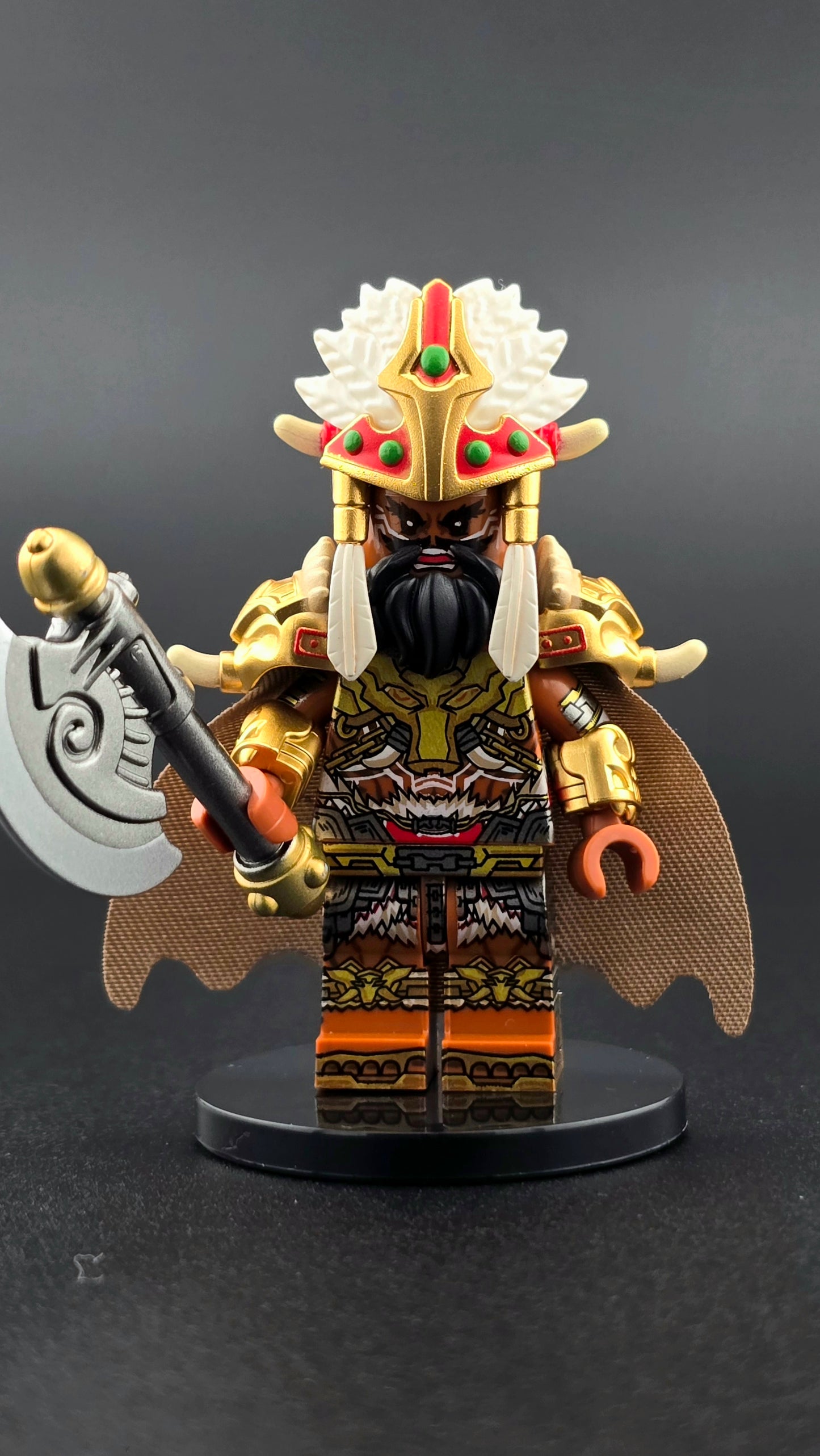 Custom fantasy inspired Bone Tribe Warlord minifigure with intricate headdress, brown and white armor, golden accents, black beard, cape, and axe accessory. Detailed warrior chieftain design compatible with leading brick style building sets.