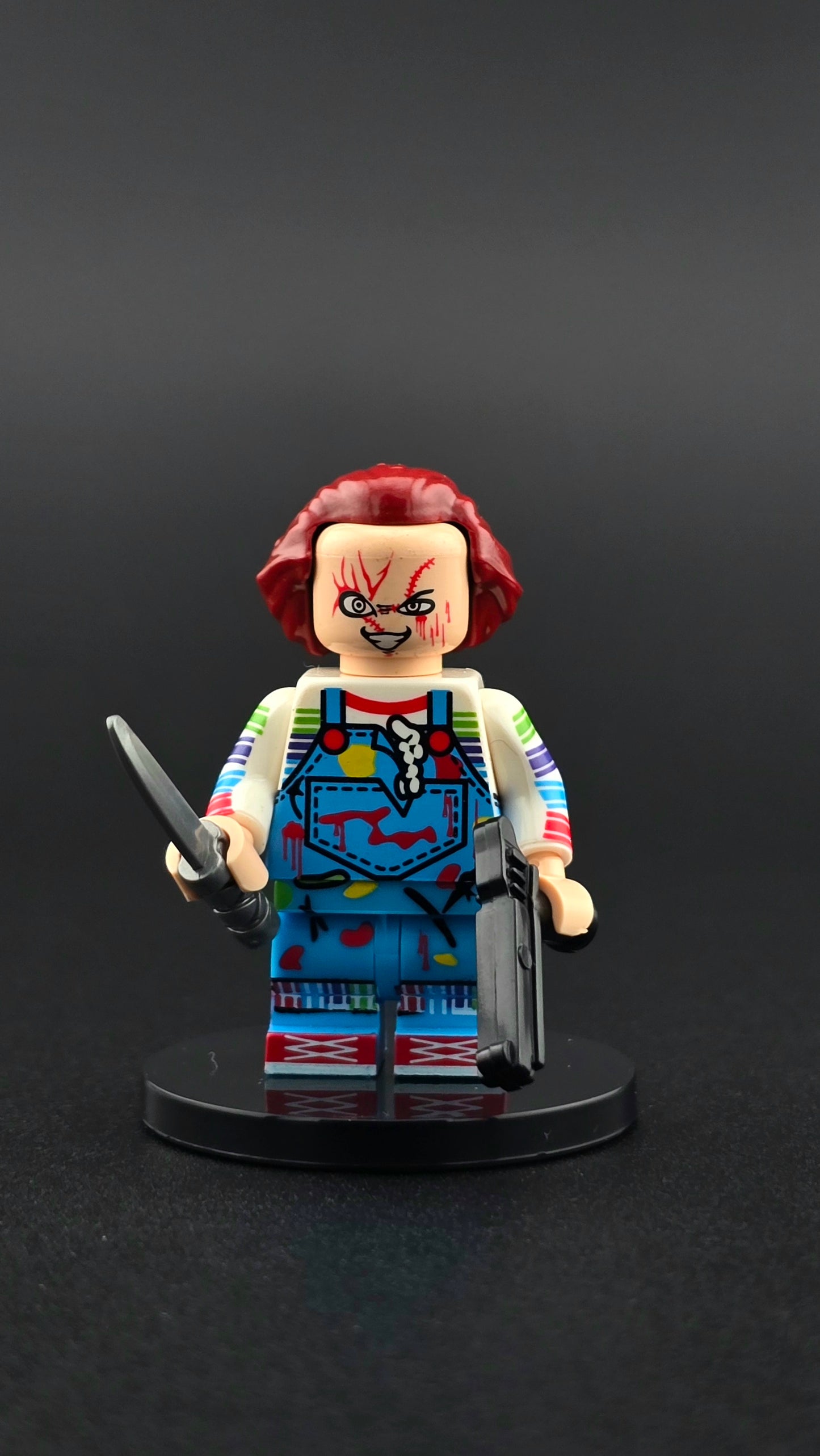 Custom horror inspired minifigure in blue and red outfit with crazed expression, holding a knife and gun. Detailed villain themed design compatible with leading brick style building sets.