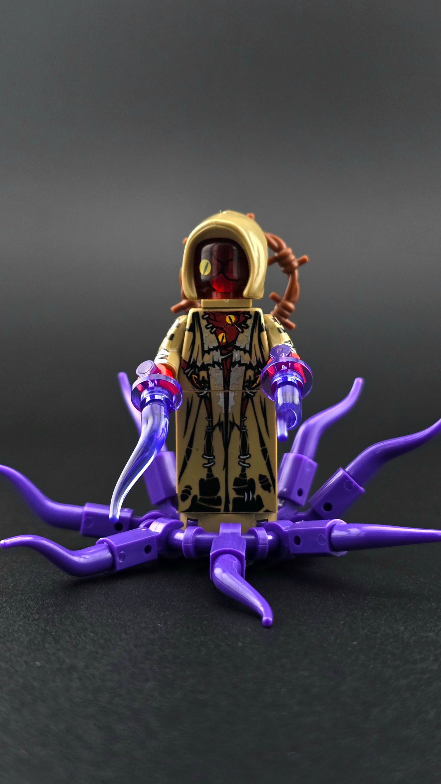Custom Lovecraft inspired minifigure with hooded design, multiple eyes, purple and tan colours, and tentacle accessory. Eldritch themed figure with detailed horror styling compatible with leading brick style building sets.