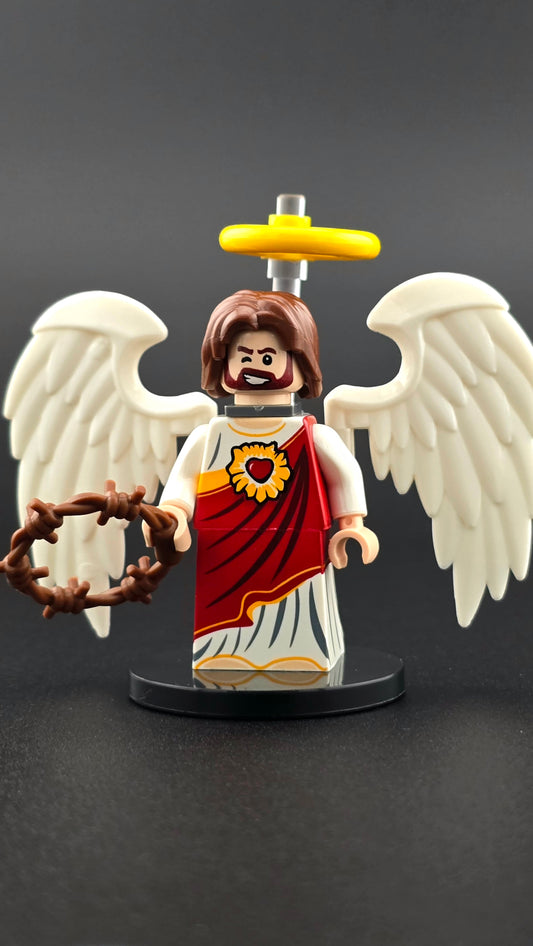 Custom religion-inspired resurrected figure with smiling, winking expression, red and white clothing, golden halo, white wings, and wreath accessory. Features symbolic colors and detailed elements compatible with leading brick-style building systems.