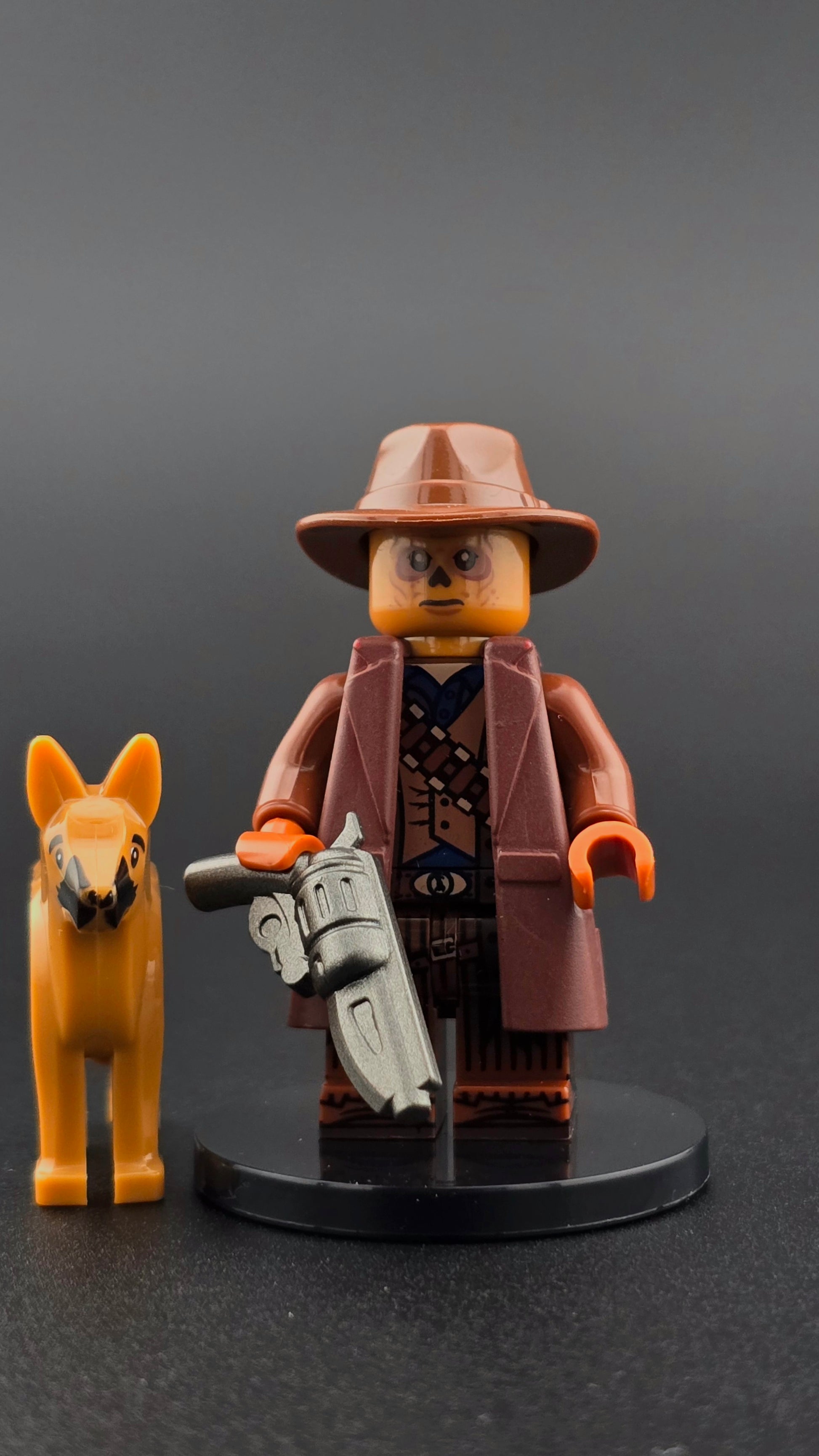 Custom Fallout inspired ghoul minifigure in brown tones with weathered details, cowboy hat, gun accessory, and Dogmeat companion piece. Detailed post apocalyptic design compatible with leading brick style building sets.