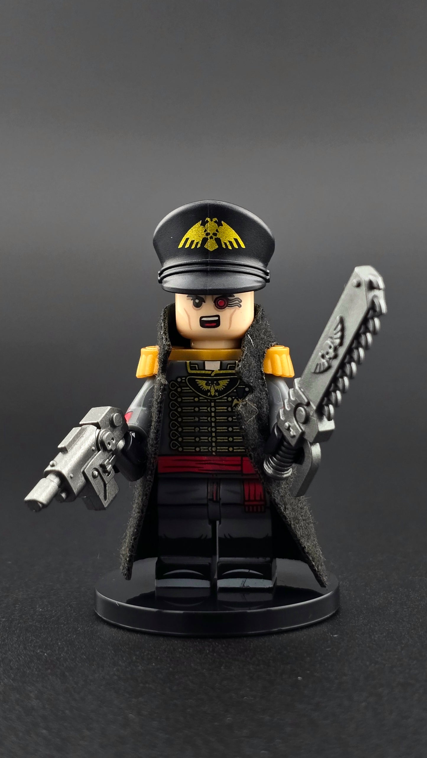 Custom sci fi inspired Commisar minifigure with black and gold uniform, cape, shouting expression, ripper blade, and pistol. Detailed futuristic officer design compatible with leading brick style building sets.