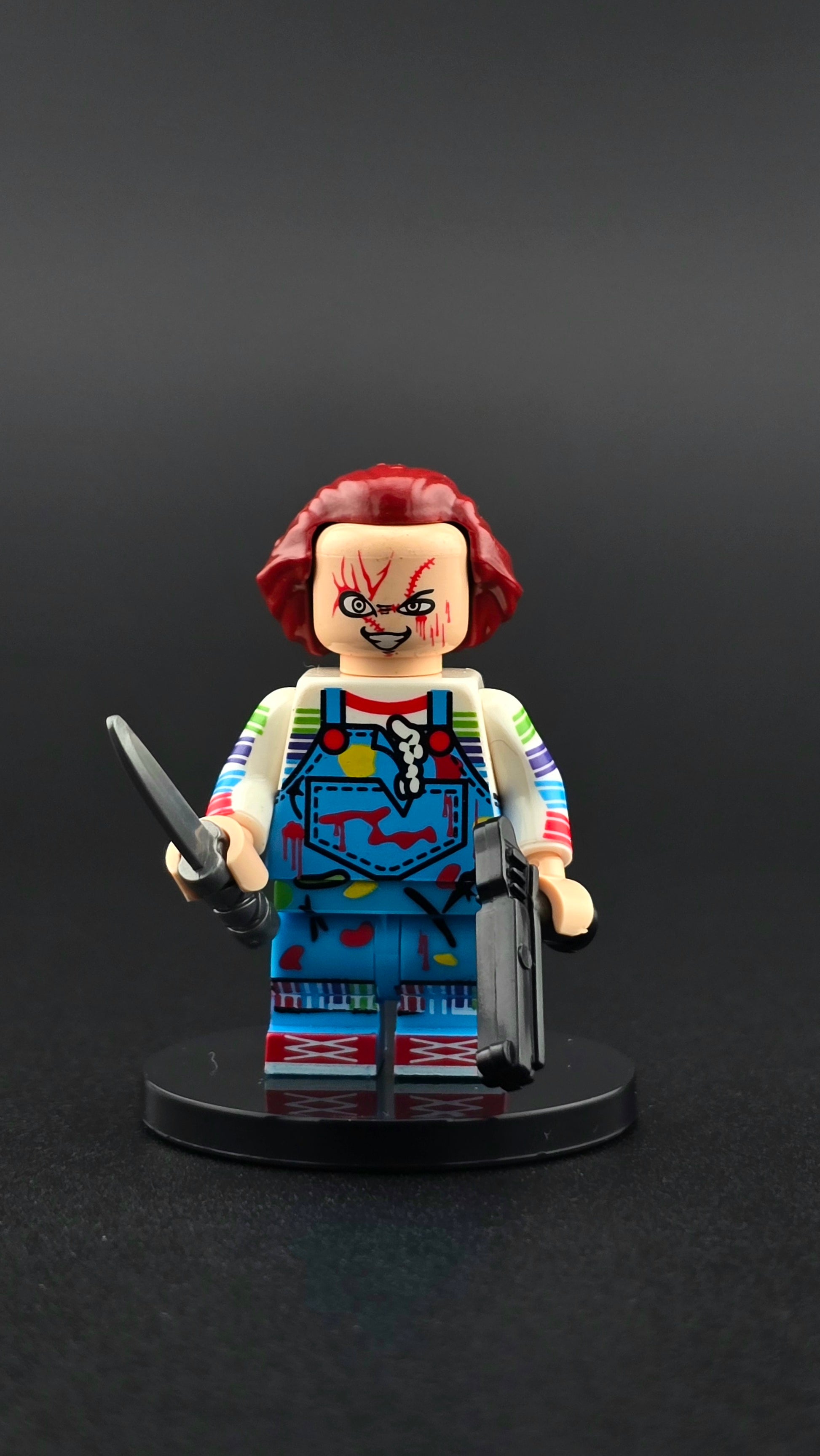 Custom horror inspired minifigure in blue and red outfit with crazed expression, holding a knife and gun. Detailed villain themed design compatible with leading brick style building sets.