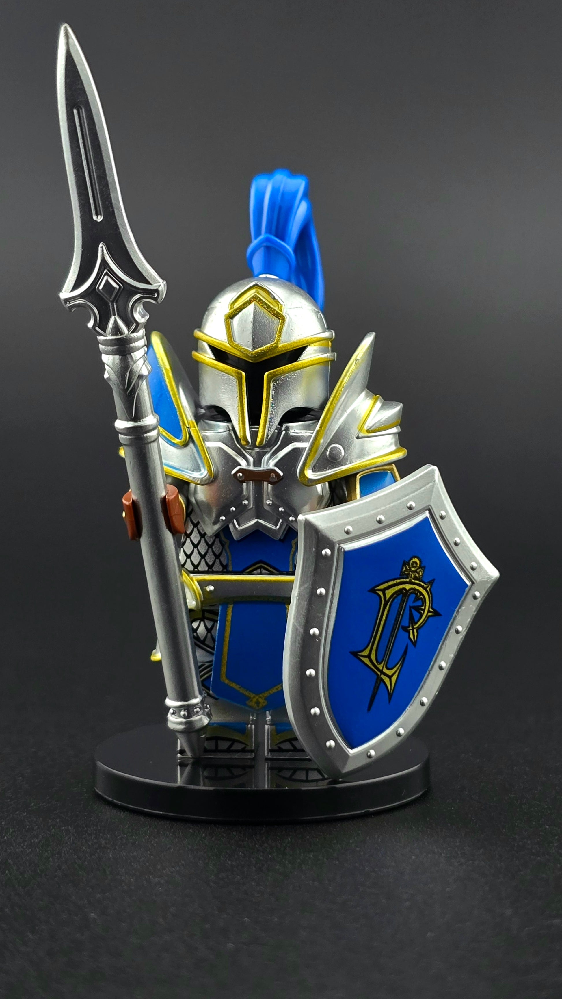 Custom fantasy inspired Knight Footman minifigure with royal blue and silver heavy armor, helmet, spear, and shield. Designed for regal fantasy battle displays and compatible with leading brick style building sets.
