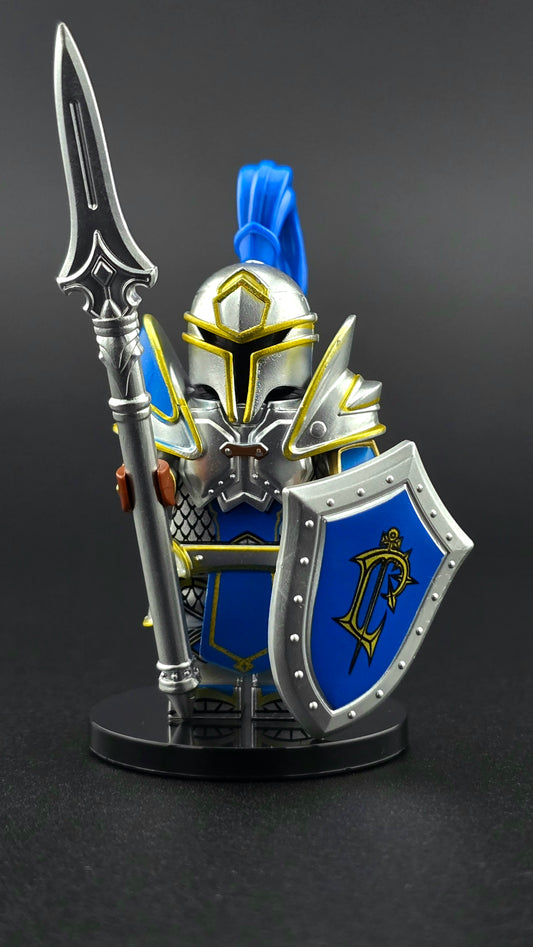 Custom fantasy inspired Knight Footman minifigure with royal blue and silver heavy armor, helmet, spear, and shield. Designed for regal fantasy battle displays and compatible with leading brick style building sets.