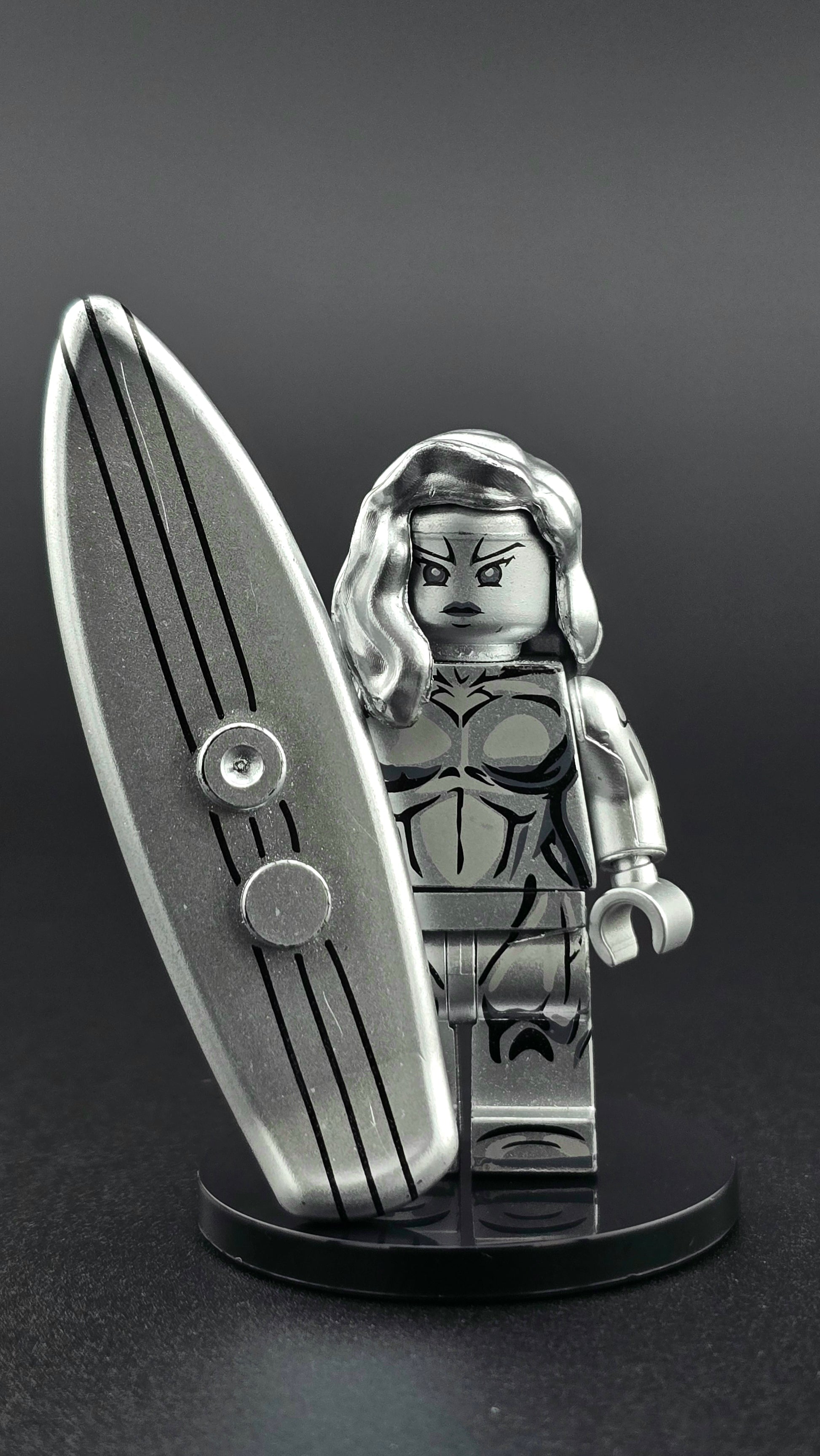 Custom female-inspired Silver Surfer minifigure in full metallic silver finish, posed with a matching silver surfboard and designed for compatibility with leading brick-style building systems.