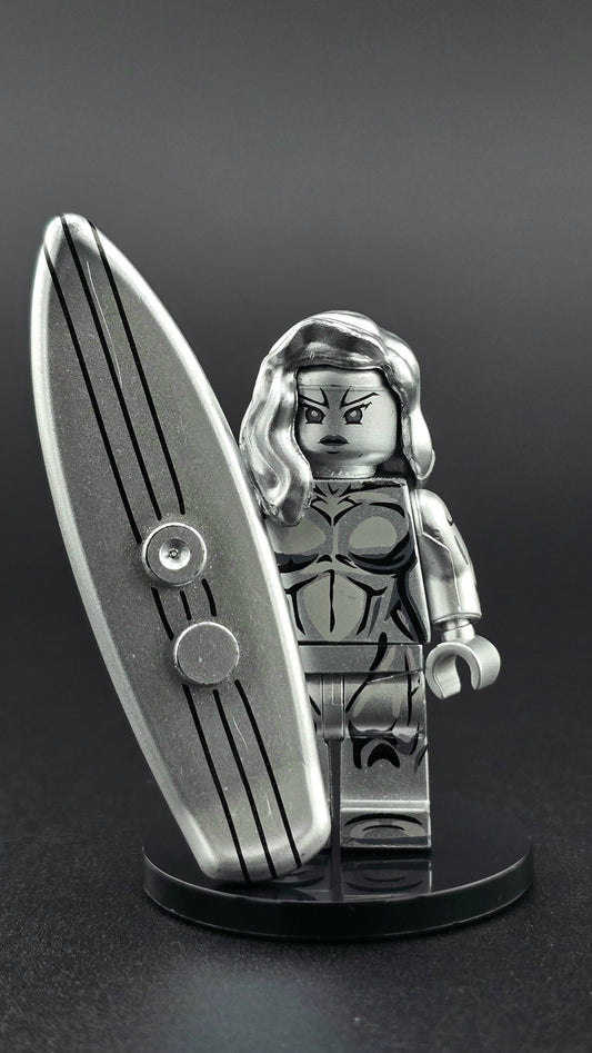 Custom female-inspired Silver Surfer minifigure in full metallic silver finish, posed with a matching silver surfboard and designed for compatibility with leading brick-style building systems.