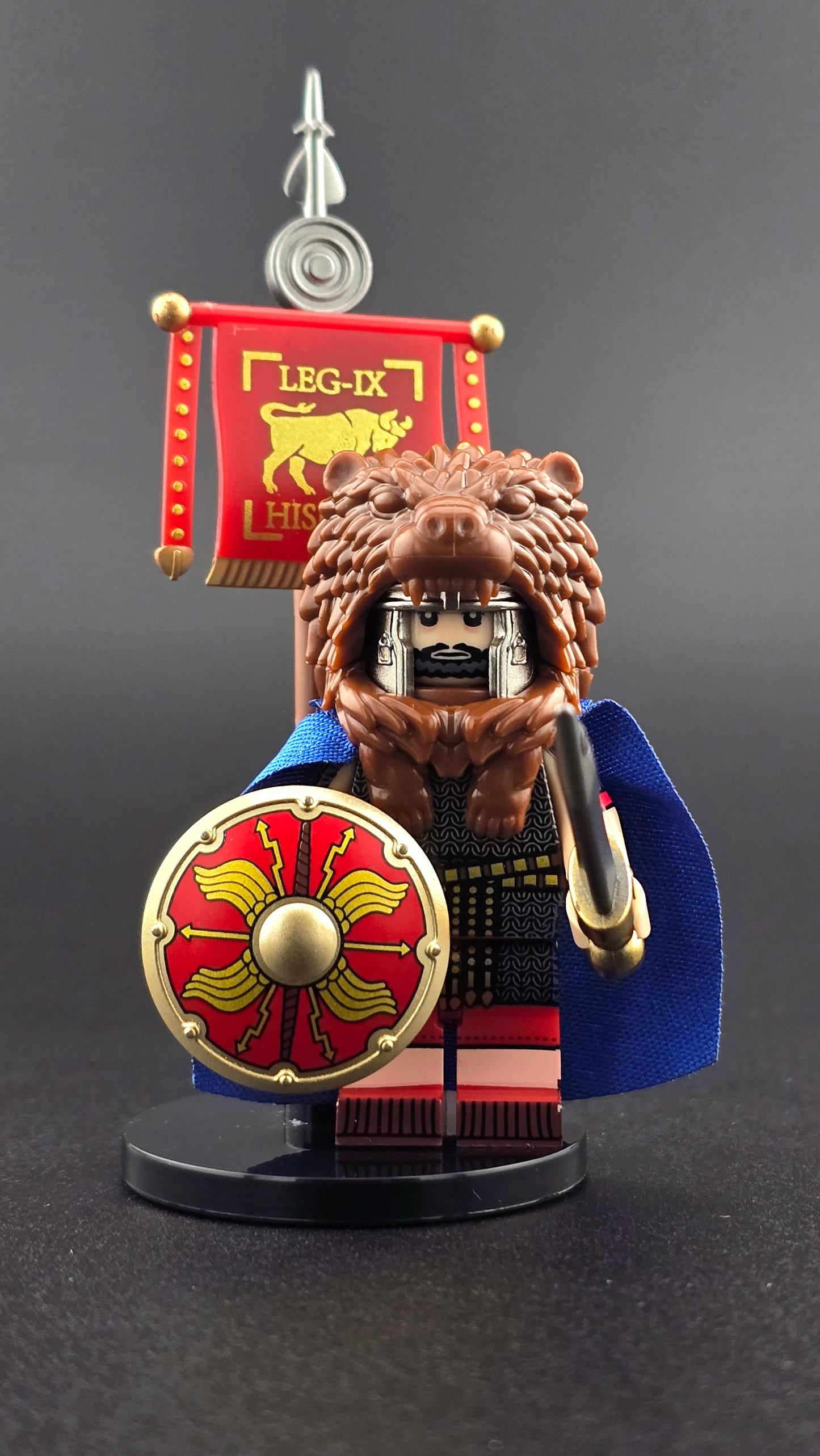 Custom Roman Velite Soldier minifigure featuring animal pelt helmet, legionnaire standard, shield, sword, and cape, inspired by Ancient Rome and compatible with leading brick-style building systems.