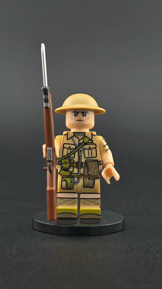 Custom WWII British Gunner minifigure in desert uniform with helmet and rifle, inspired by British forces in North Africa and compatible with leading brick-style building systems.