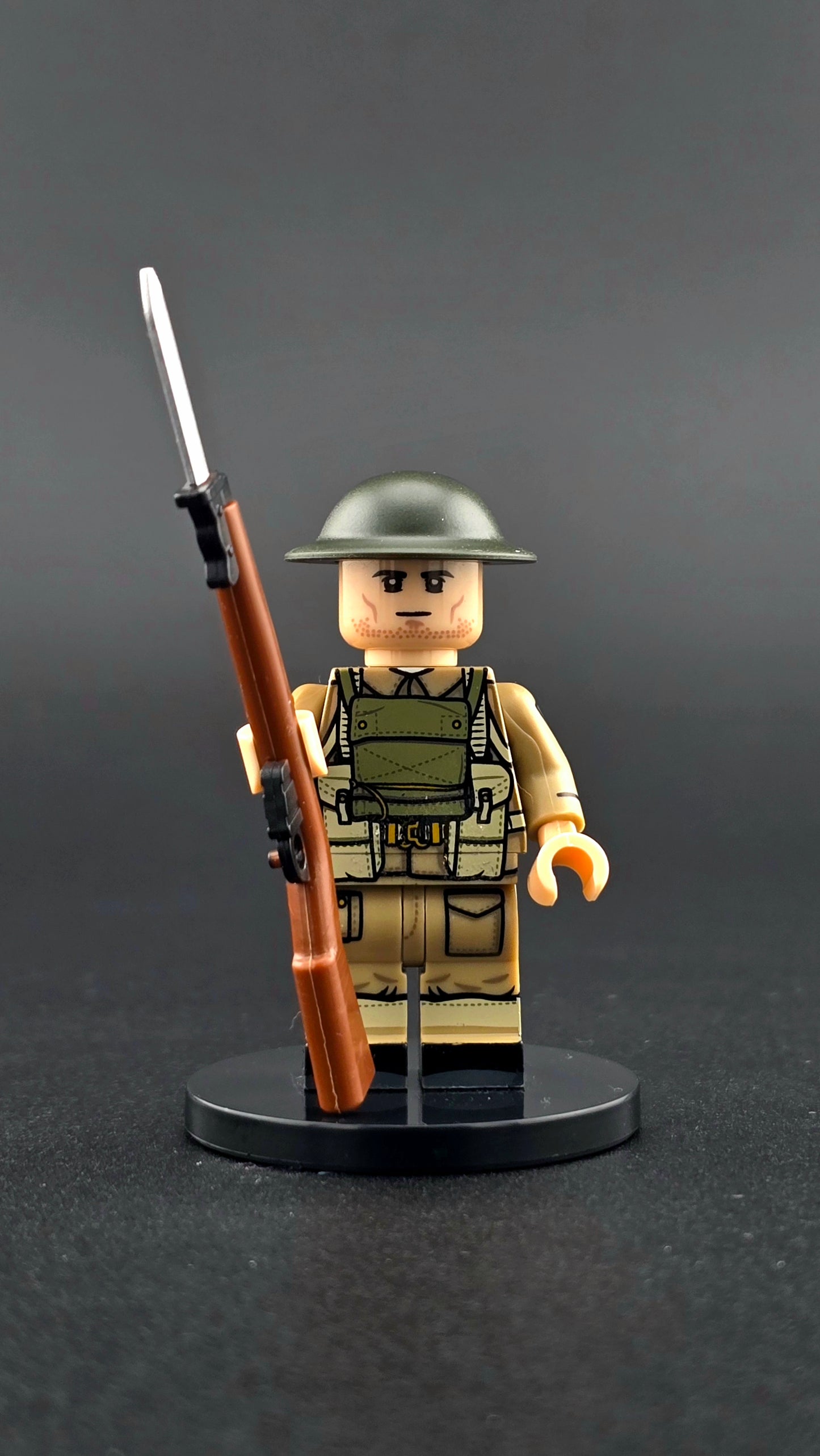 Custom WWII British Infantry Soldier minifigure wearing classic khaki uniform with helmet and rifle, inspired by Great Britain forces and compatible with leading brick-style building systems.